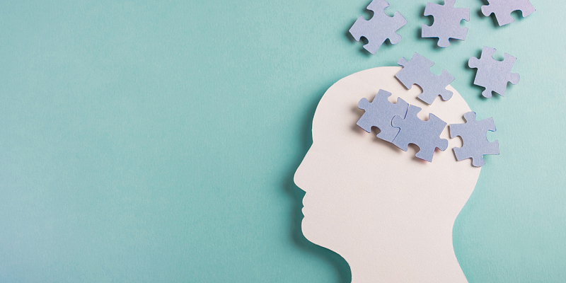 Side view of a human head with jigsaw pieces scattered around, suggesting cognitive load in digital accessibility design